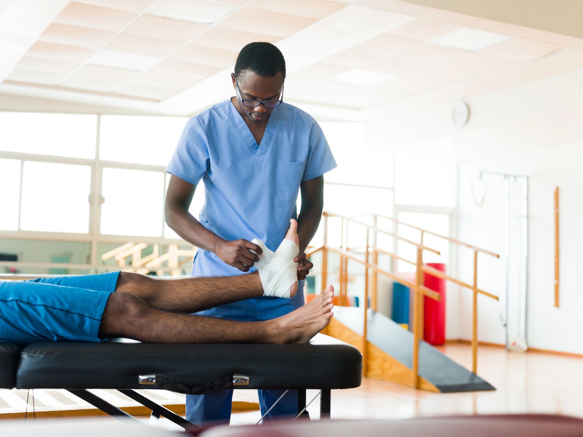 Healthcare professional wrapping a patient's foot with bandage