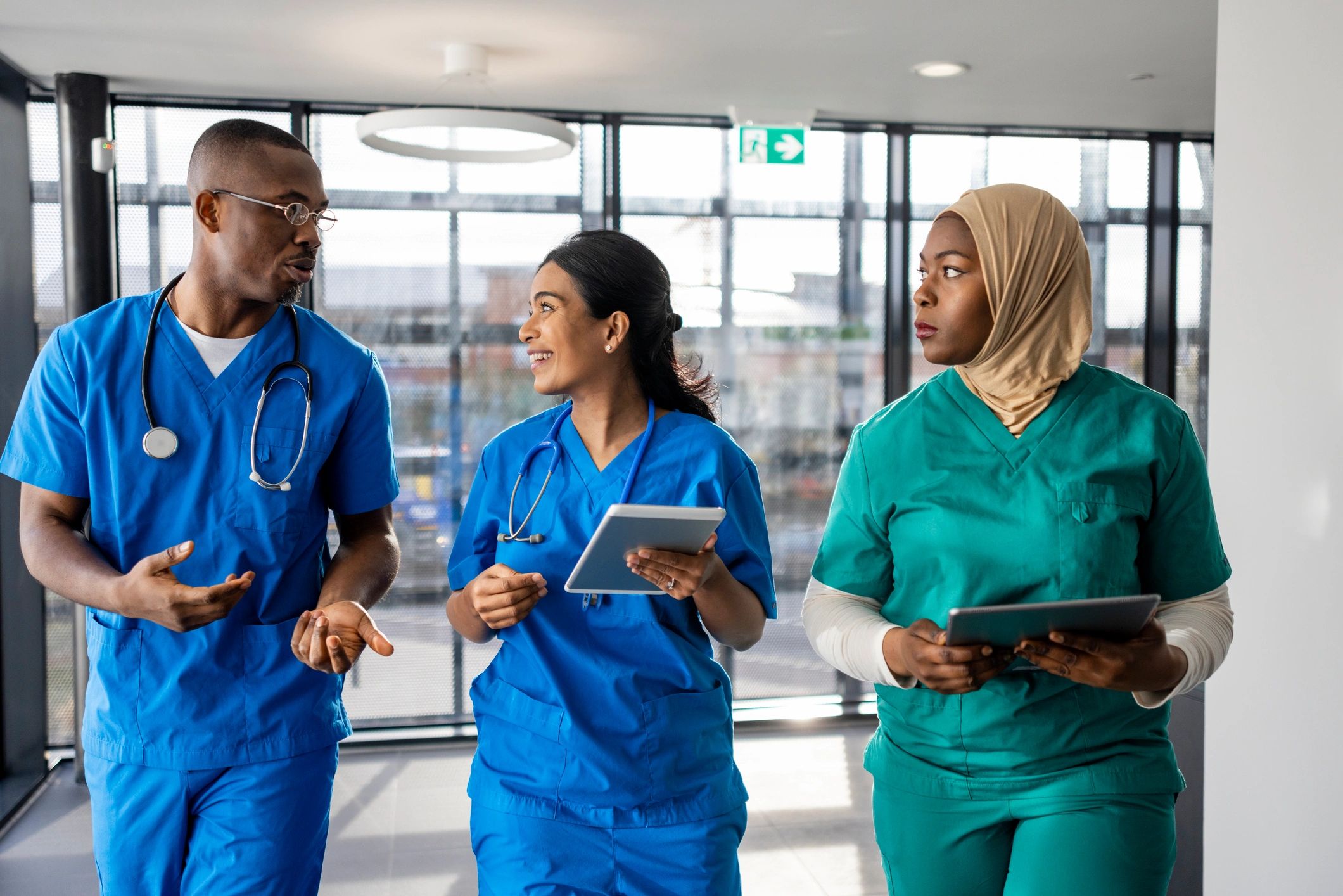Hospital team walking with tablets in a corridor